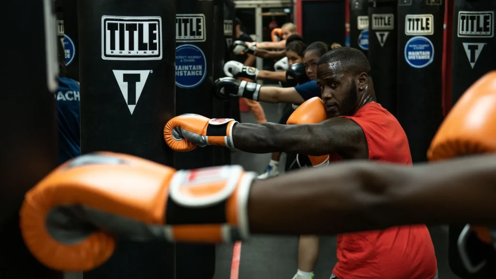 Group of athletes working on heavy bags during a HIIT boxing class