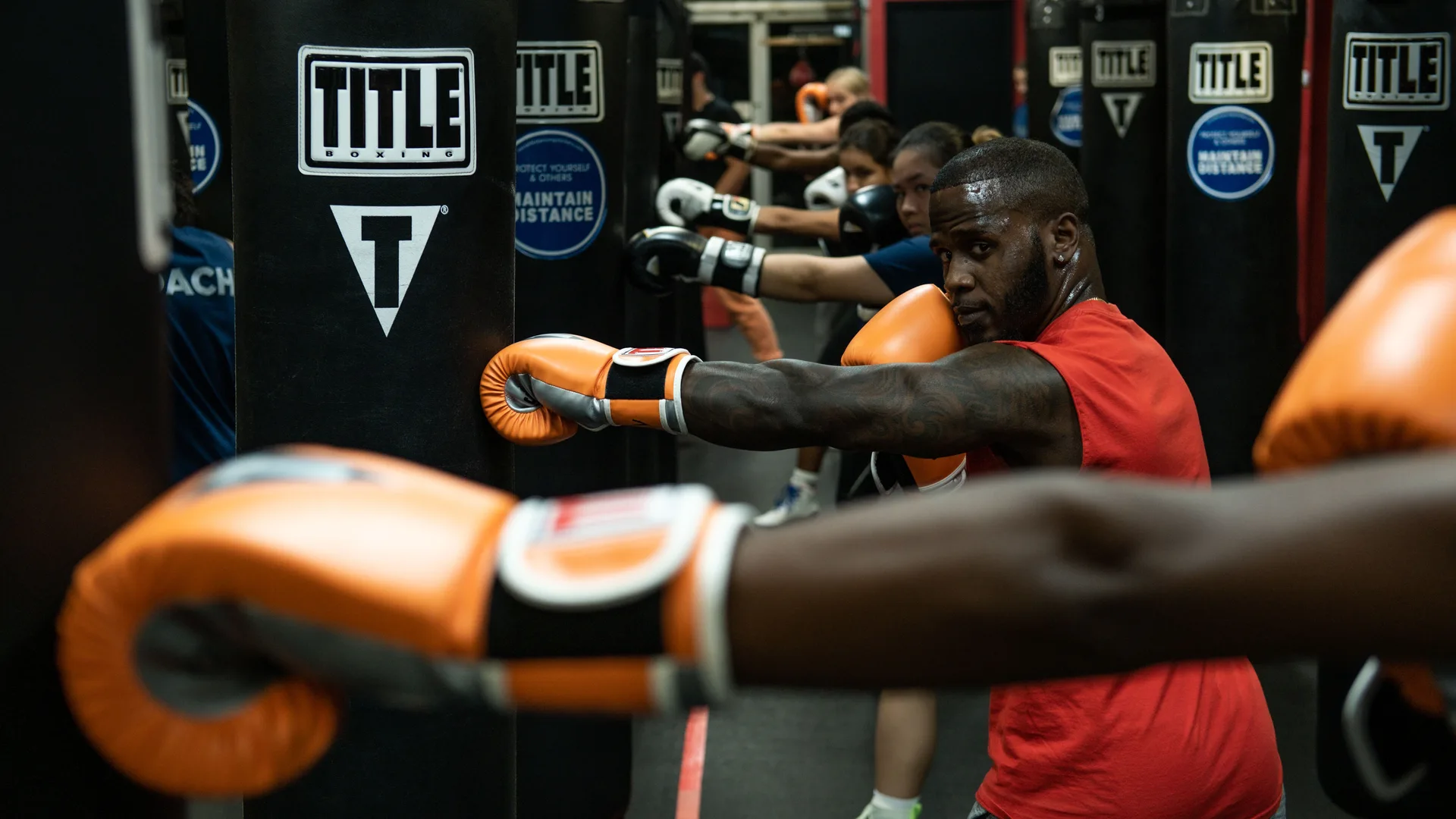 Group of athletes working on heavy bags during a HIIT boxing class
