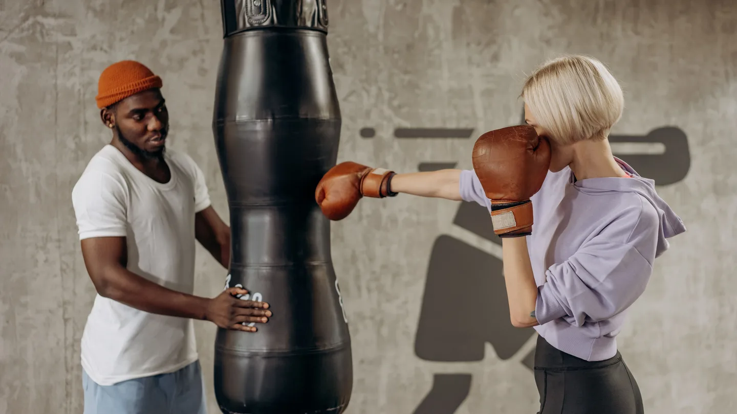 Woman boxing with a coach during an indoor boxing workout