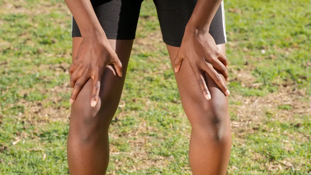Athlete resting with hands on knees after a hard workout